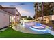 Inviting backyard oasis with a modern pool, integrated jacuzzi, lush landscaping, and outdoor living space at 9417 Churchill Downs Dr, Las Vegas, NV 89117