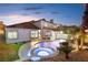 Backyard featuring a custom pool and jacuzzi surrounded by well-maintained landscaping and ample patio space at 9417 Churchill Downs Dr, Las Vegas, NV 89117