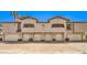 Home exterior featuring multiple garage doors and unit numbers under the balcony windows at 104 Breezy Tree Ct # 201, Las Vegas, NV 89145