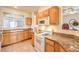 Kitchen with granite countertops, wood cabinets, and white appliances with a window view at 104 Breezy Tree Ct # 201, Las Vegas, NV 89145