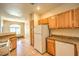 Kitchen with tile floors, wood cabinets, granite countertops, and white appliances at 104 Breezy Tree Ct # 201, Las Vegas, NV 89145
