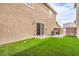 This backyard has artificial turf, a patio and a sliding glass door at 1115 Brilliant Meadow Ave, North Las Vegas, NV 89086