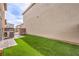 Backyard featuring artificial grass and a brick-paved area, perfect for outdoor entertaining at 1115 Brilliant Meadow Ave, North Las Vegas, NV 89086