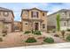 View of a two-story home with stone accents, desert landscaping, and tiled roof at 1115 Brilliant Meadow Ave, North Las Vegas, NV 89086