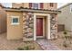 Close up view of the front door with stone accents and stylish exterior lighting at 1115 Brilliant Meadow Ave, North Las Vegas, NV 89086