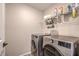 Modern laundry room featuring stainless steel, front-load washer and dryer at 1115 Brilliant Meadow Ave, North Las Vegas, NV 89086