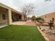 Backyard showcasing artificial grass, a covered patio, and a water feature for outdoor enjoyment at 1654 Danbury Crossing Dr, Henderson, NV 89052