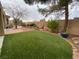 Large backyard with artificial grass, mature landscaping, and hardscape, perfect for outdoor living at 1654 Danbury Crossing Dr, Henderson, NV 89052