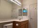 Bathroom featuring a single sink vanity, a large mirror, and classic white fixtures at 1654 Danbury Crossing Dr, Henderson, NV 89052