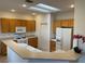 Bright kitchen with wood cabinets, white appliances, tile floors, and a skylight for natural light at 1654 Danbury Crossing Dr, Henderson, NV 89052