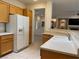 Kitchen featuring wooden cabinets, white appliances, tile flooring and ample counter space at 1654 Danbury Crossing Dr, Henderson, NV 89052