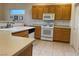 Kitchen featuring wooden cabinets, white appliances, tile flooring and ample counter space at 1654 Danbury Crossing Dr, Henderson, NV 89052