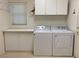 Bright laundry room featuring a washer, a dryer, a folding counter, and storage cabinets at 1654 Danbury Crossing Dr, Henderson, NV 89052