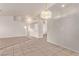 Bright living room featuring neutral tile flooring and a modern chandelier, perfect for entertaining and relaxing at 178 Beach Oak Ave, Henderson, NV 89002