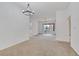 Spacious open-plan living room is well-lit with an inviting chandelier and neutral carpet at 19 E Agate Ave # 402, Las Vegas, NV 89123