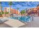 Exterior community pool with lounge chairs, palm trees, and a clear blue sky at 19 E Agate Ave # 402, Las Vegas, NV 89123