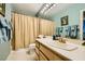 Bathroom with a single sink vanity, a shower with a curtain, and blue towels on a rack at 2012 Lady Lake St, Las Vegas, NV 89128