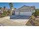 Attractive home boasts a large driveway leading to a three-car garage and a well-cared-for lawn at 2012 Lady Lake St, Las Vegas, NV 89128