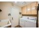 Functional laundry room features a washer, dryer, storage cabinets, and utility sink at 2012 Lady Lake St, Las Vegas, NV 89128