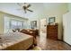Bright main bedroom featuring a large bed, dresser, seating area, and a glimpse into the bathroom at 2012 Lady Lake St, Las Vegas, NV 89128