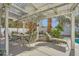 Relaxing covered patio features a dining table with chairs and a lounge chair in a serene outdoor setting at 2012 Lady Lake St, Las Vegas, NV 89128