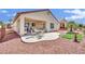 Backyard showcasing covered patio, desert landscaping, manicured lawn, and outdoor seating area at 2077 Wildwood Lake St, Henderson, NV 89052