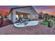 A well-maintained backyard with a covered patio, seating, and desert landscaping at 2077 Wildwood Lake St, Henderson, NV 89052