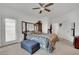 Spacious bedroom featuring a ceiling fan, carpeted floor, mirrored closet, and access to an ensuite bathroom at 2077 Wildwood Lake St, Henderson, NV 89052