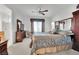 Comfortable carpeted bedroom with natural lighting, ceiling fan, ensuite bathroom, and mirrored closet at 2077 Wildwood Lake St, Henderson, NV 89052