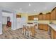 Bright kitchen with wood cabinets, laminate floors, and a large center island with seating at 2077 Wildwood Lake St, Henderson, NV 89052