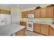 Bright kitchen featuring white appliances, laminate floors, and wood cabinetry at 2077 Wildwood Lake St, Henderson, NV 89052