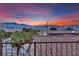 View of a desert landscape with a terracotta tile roof featuring solar panels with a vibrant sunset at 2077 Wildwood Lake St, Henderson, NV 89052