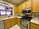The kitchen features stainless steel appliances, wooden cabinets and a window to the living room at 2270 Canyon Song Ave, Laughlin, NV 89029