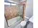 Modern bathroom featuring a bathtub and shower with sliding glass doors and tile surround at 2428 Greens Ave, Henderson, NV 89014