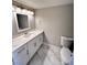 Well-lit bathroom features a modern vanity with quartz countertop and stylish marble floors at 2428 Greens Ave, Henderson, NV 89014