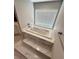 A modern bath tub with marble steps next to a window at 2428 Greens Ave, Henderson, NV 89014