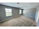 Spacious bedroom with neutral carpet and natural light from two large windows at 2428 Greens Ave, Henderson, NV 89014