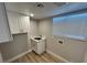 Functional laundry room with overhead cabinets and a sink with quartz countertop at 2428 Greens Ave, Henderson, NV 89014
