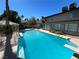 Backyard pool with diving board and slide, surrounded by green foliage and a decorative gazebo at 2428 Greens Ave, Henderson, NV 89014