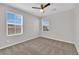 Bright bedroom features neutral walls, carpet flooring, ceiling fan, and natural light from two windows at 2449 Padulle Pl, Henderson, NV 89044