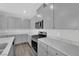 Contemporary kitchen boasting sleek gray cabinetry, marbled countertops, and stainless steel appliances at 2449 Padulle Pl, Henderson, NV 89044