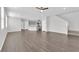Open-concept living room with gray wood floors flowing into the kitchen and a staircase leading to the upper level at 2449 Padulle Pl, Henderson, NV 89044