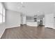 Bright, open living area featuring hardwood floors, leading to a modern kitchen with stainless steel appliances at 2449 Padulle Pl, Henderson, NV 89044