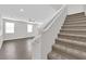Spacious view of open floor plan with carpeted staircase leading to upper level with ceiling fan and hardwood floors at 2449 Padulle Pl, Henderson, NV 89044