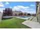Beautiful backyard with a swimming pool, lush green lawn, and tasteful landscaping at 2804 Candelaria Dr, Henderson, NV 89074