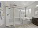 Bathroom with a glass enclosed shower, soaking tub, and shuttered windows at 2804 Candelaria Dr, Henderson, NV 89074