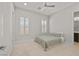 Cozy bedroom featuring a simple bed, neutral carpet, plantation shutters, and modern ceiling fan at 2804 Candelaria Dr, Henderson, NV 89074