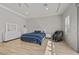 Bright bedroom features a bed with blue bedding, light wood floors, and massage chair at 2804 Candelaria Dr, Henderson, NV 89074