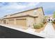 View of the garages of the townhome-style homes with desert landscaping and neutral stucco finish at 2871 Cabrillo Terrace St, Henderson, NV 89044