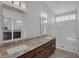 Bathroom featuring a granite countertop, double sinks, and a glass-enclosed shower at 301 Montcliff Ave, Henderson, NV 89074